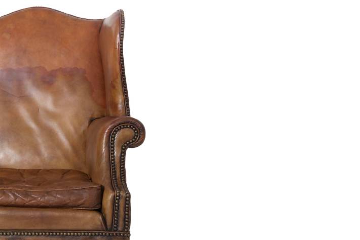 Antica coppia di poltrone wing back o bergere inglese originale in cuoio cognac